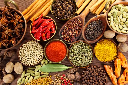 Spices and herbs in metal bowls and wooden spoons. Food and cuisine ingredients.