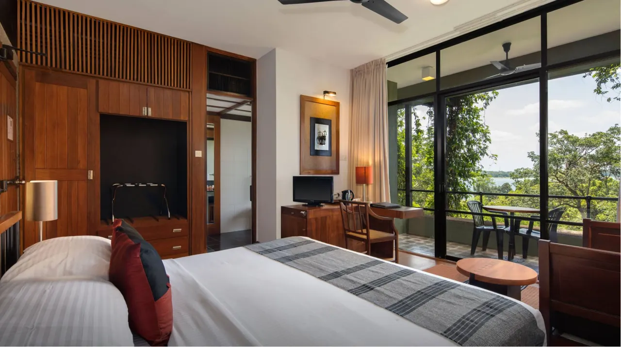 Bed and window in a Heritance Kandalama Superior room