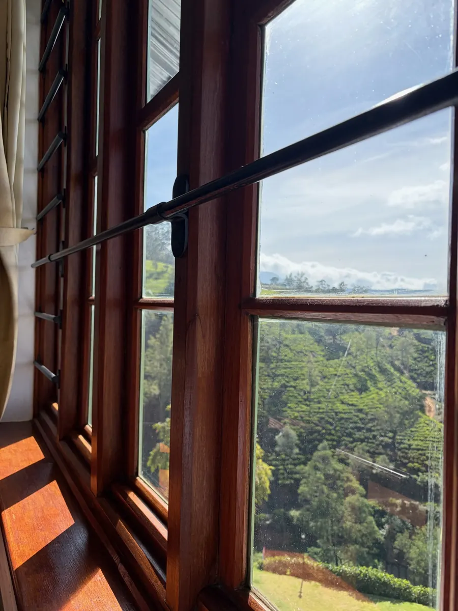 Tea-country view through a window — Heritance Tea Factory
