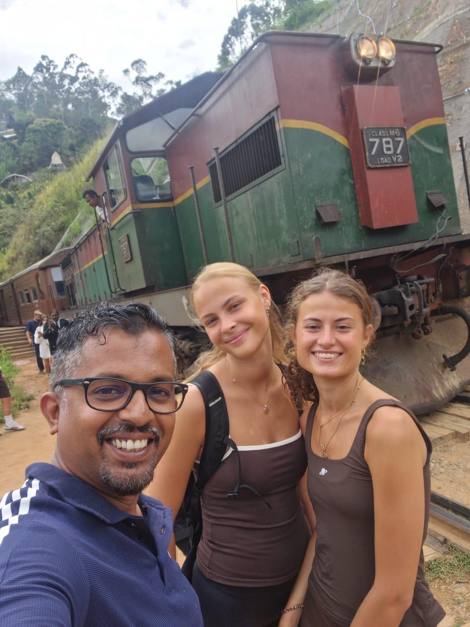 Women travellers enjoying Sri Lanka with local driver support near a scenic train